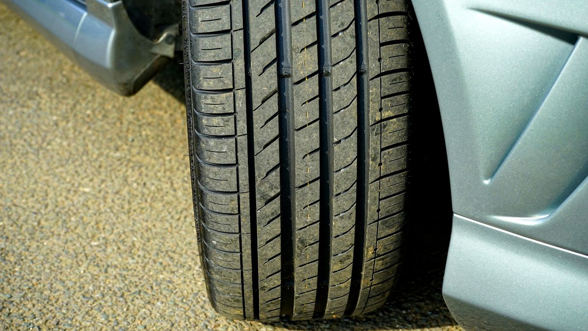 Close-up of a modern car tyre tread on clean asphalt