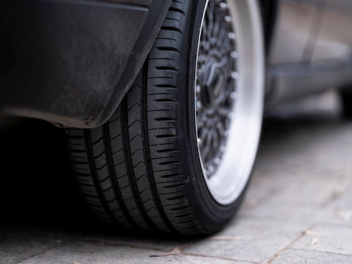 Car tyre and alloy wheel on urban pavement