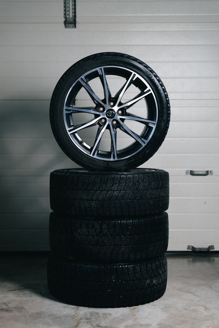 Stack of new car tyres with an alloy wheel