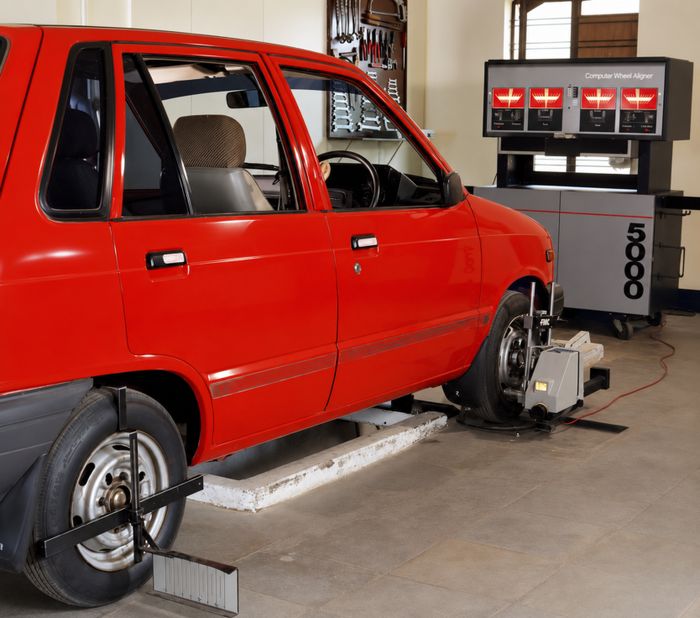 Car undergoing computerized wheel alignment in a workshop