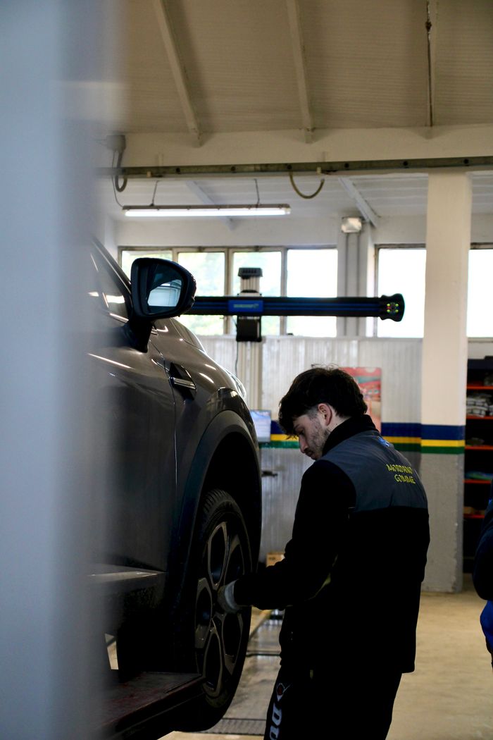Mechanic working on a car tyre in a workshop