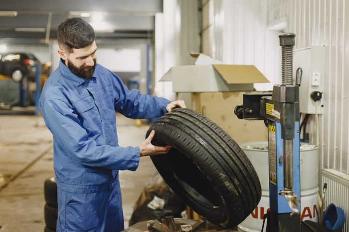 Mechanic examining a tyre in an automotive garage