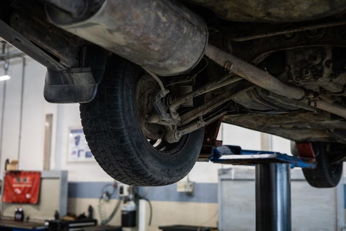 Close-up of a car's underside during inspection at a service station